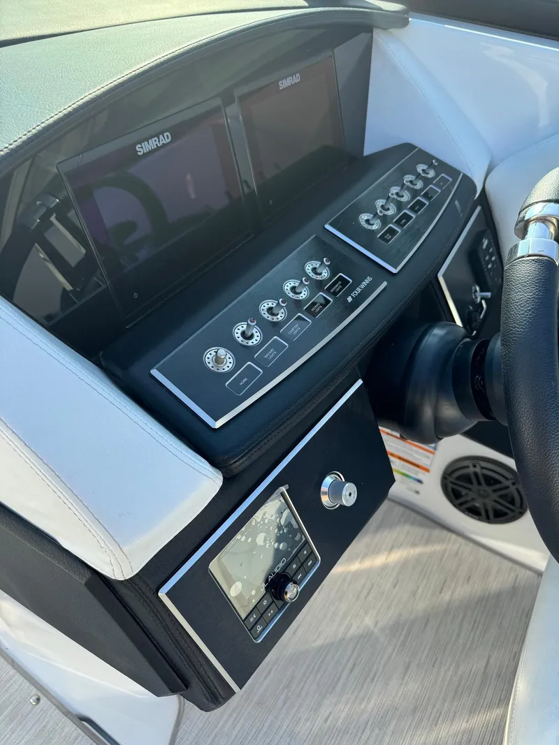 Slide: The Image of 2025 Four Winns H6 OB boat dashboard with modern controls and Simrad displays. - 14