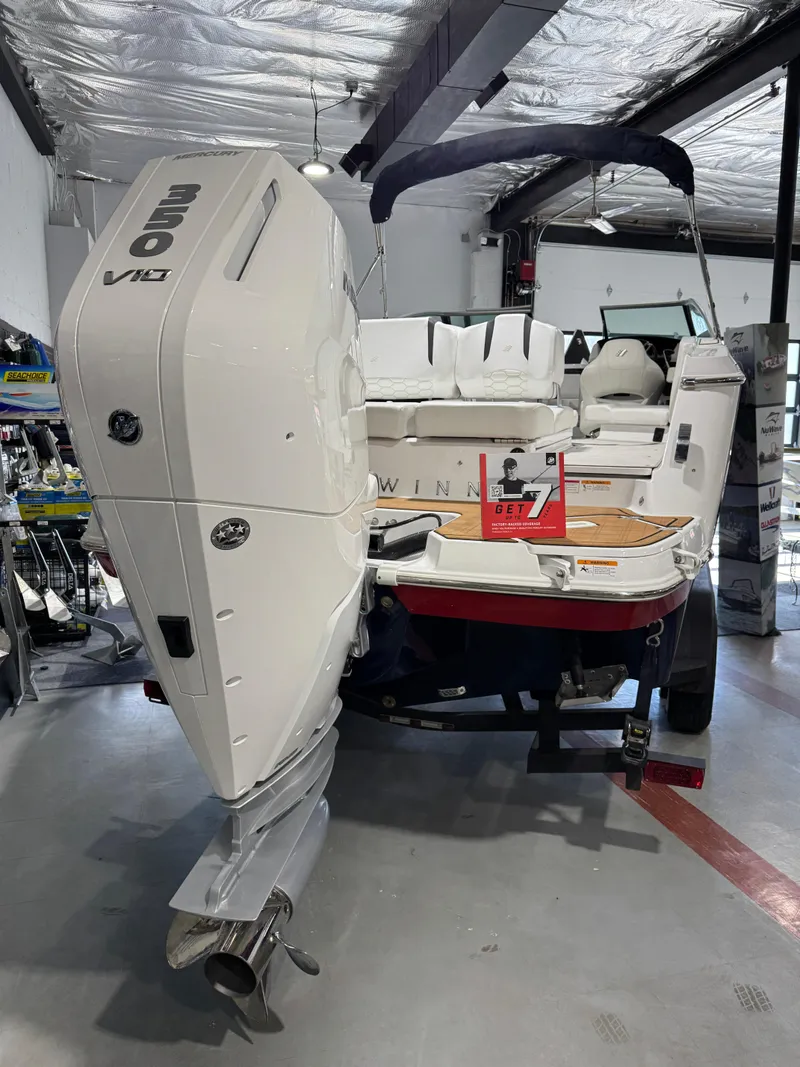 Slide: The Image of 2025 Four Winns H6 OB boat with powerful engine in a showroom setting. - 17