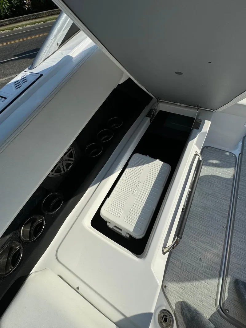 Slide: The Image of 2025 Four Winns H6 OB boat storage compartment with cooler and cup holders. - 33