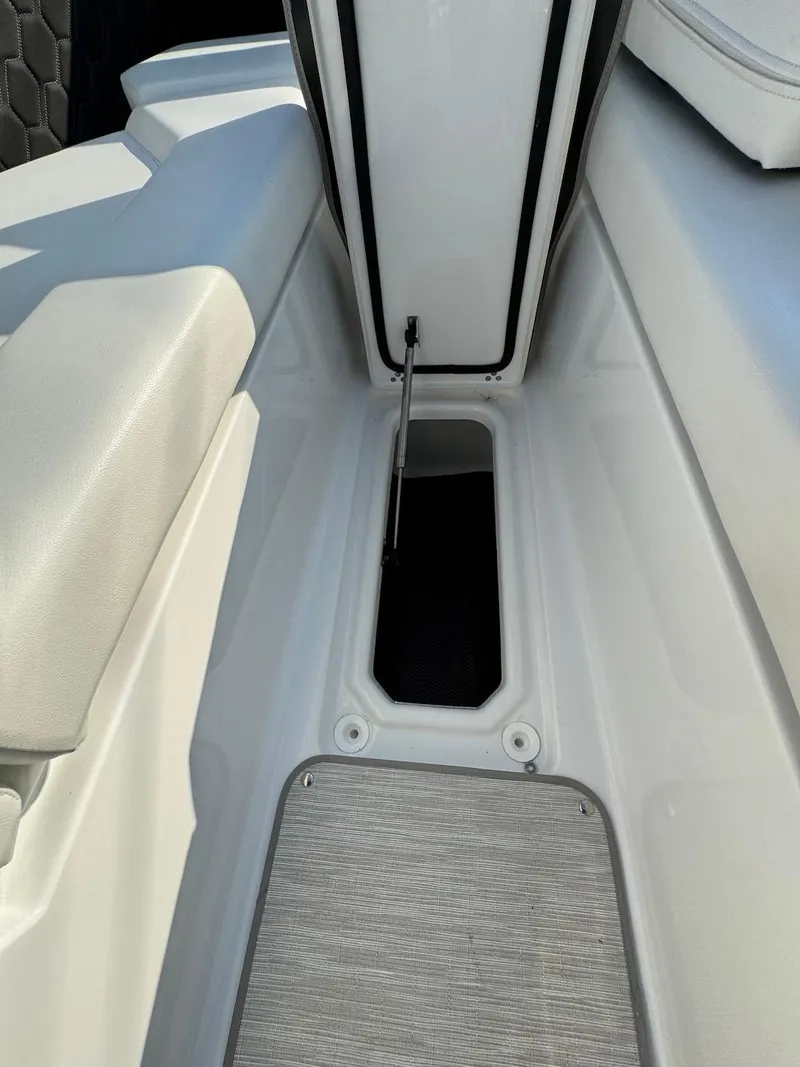 Slide: The Image of 2025 Four Winns H6 OB boat interior storage compartment with cushioned seating. - 34