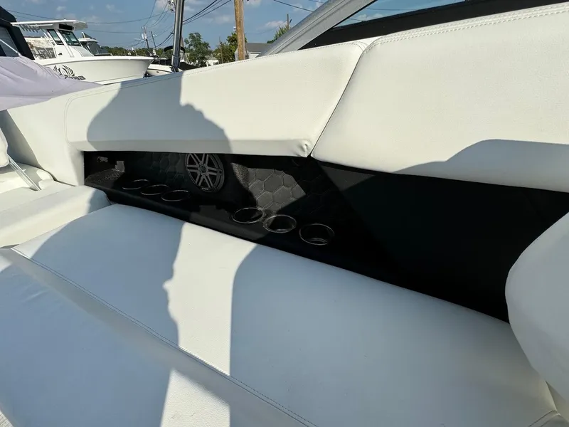 Slide: The Image of 2025 Four Winns H6 OB boat interior with white seating and cup holders. - 8