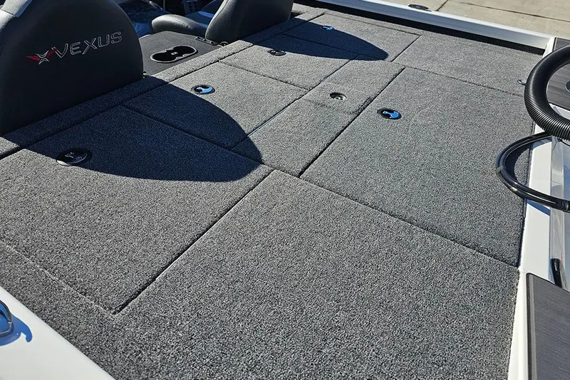 Slide: The Image of 2026 Vexus Defender 189 boat deck with gray carpet and storage compartments. - 10