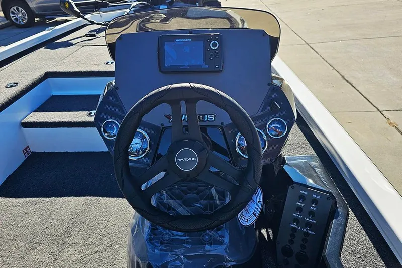 Slide: The Image of 2026 Vexus Defender 189 boat dashboard with steering wheel and control panel. - 12