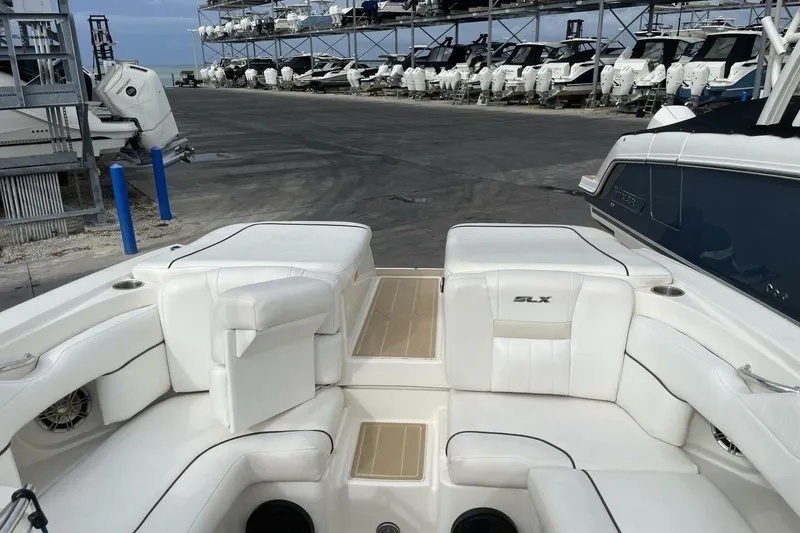 Slide: The Image of 2008 Sea Ray 270 SLX boat interior with white seating at a marina. - 19