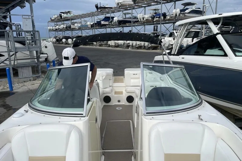 Slide: The Image of 2008 Sea Ray 270 SLX boat docked with person onboard, surrounded by other boats. - 22