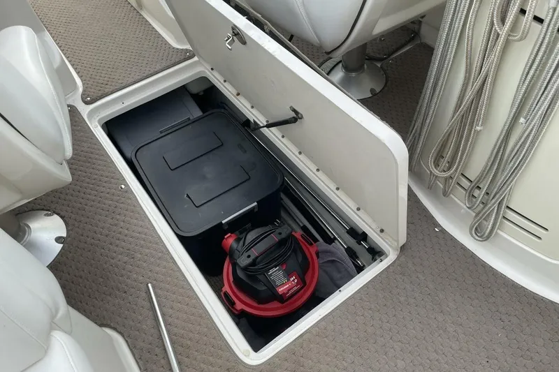 Slide: The Image of 2008 Sea Ray 270 SLX storage compartment with vacuum and container. - 31