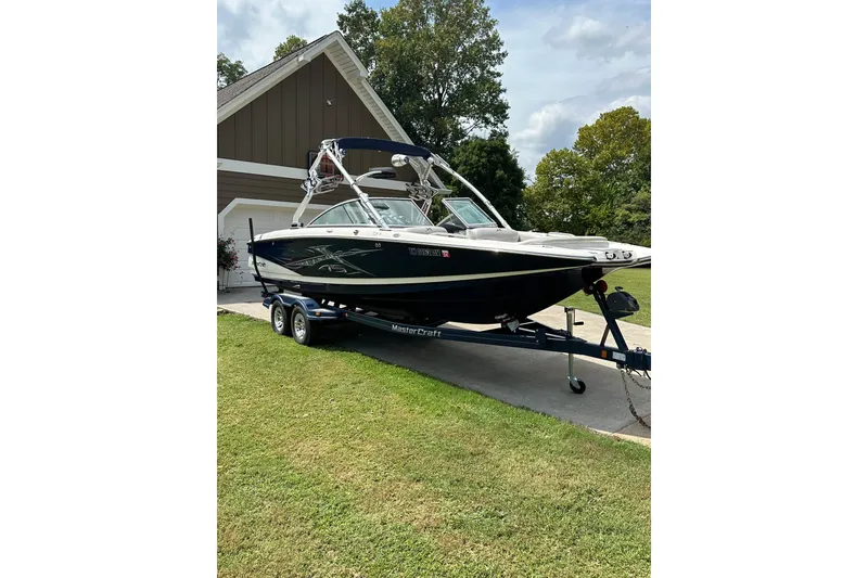 The Image of 2007 MasterCraft X-45 boat on trailer, parked in driveway near house. - 1