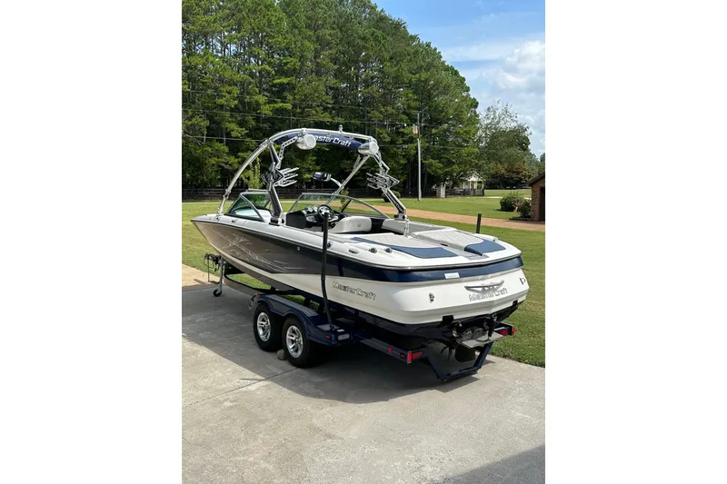 Slide: The Image of 2007 MasterCraft X-45 boat on trailer, parked outdoors with trees in background. - 3