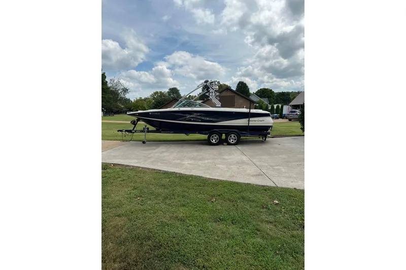 Slide: The Image of 2007 MasterCraft X-45 boat on trailer, parked on driveway, under cloudy sky. - 8