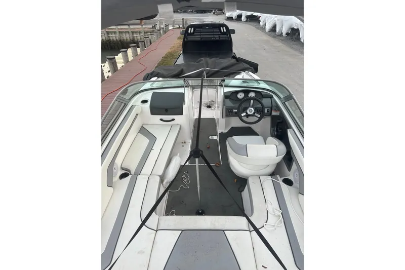 Slide: The Image of 2017 Yamaha Boats AR190 interior view, featuring seating and steering console at dockside. - 9