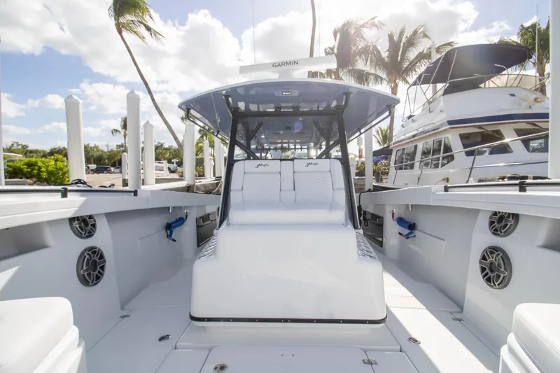 Slide: The Image of 2026 Yellowfin 42 Offshore boat with open storage compartment, docked near palm trees. - 10