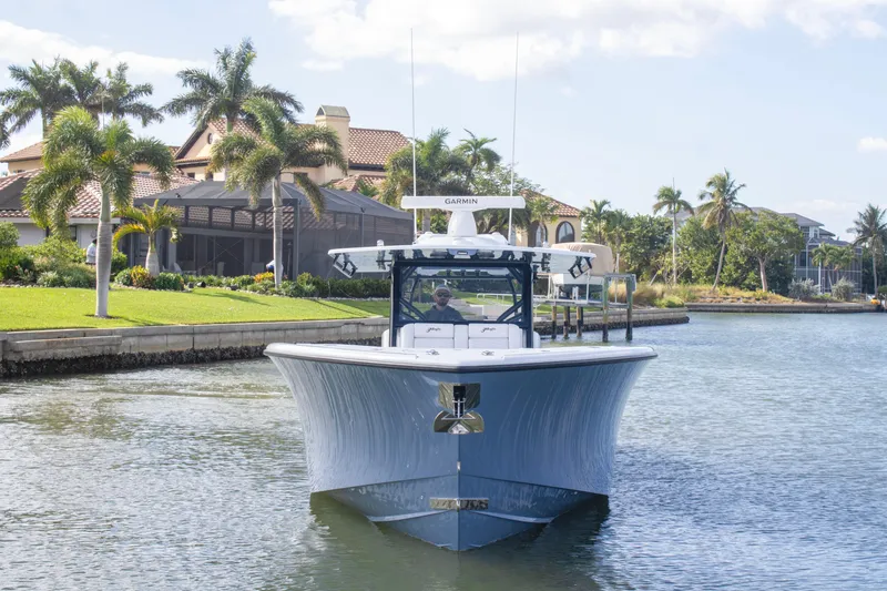 Slide: The Image of 2026 Yellowfin 42 Offshore boat with four engines cruising in a scenic canal. - 2
