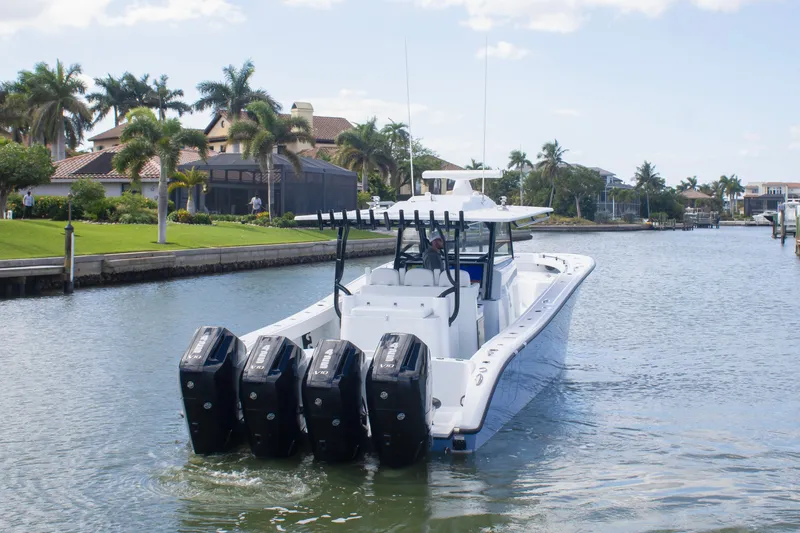 Slide: The Image of 2026 Yellowfin 42 Offshore boat cruising on a scenic waterway with palm trees. - 4