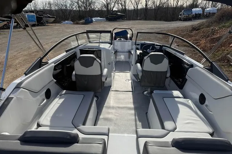 Slide: The Image of 2026 Yamaha Boats SX250 interior with seating and steering wheel, parked outdoors. - 7