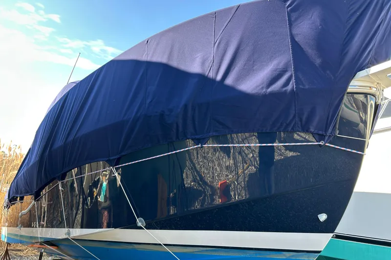 Slide: The Image of 2006 Back Cove 26 boat covered with a blue tarp, side view. - 3