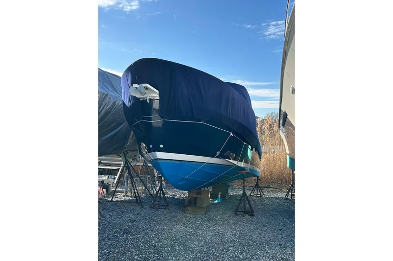 Slide: The Image of 2006 Back Cove 26 boat covered and stored on stands outdoors. - 4