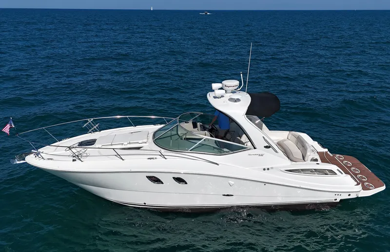 Slide: The Image of A white 2011 Sea Ray Sundancer 330 cruising on calm, blue waters. It features a sleek design. - 1