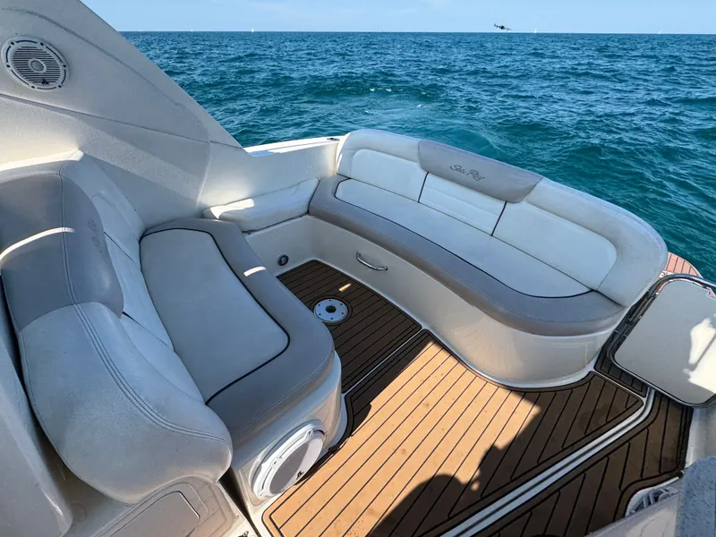 Slide: The Image of The image shows the cockpit of a 2011 Sea Ray Sundancer 330 with comfortable seating and wood flooring. - 6