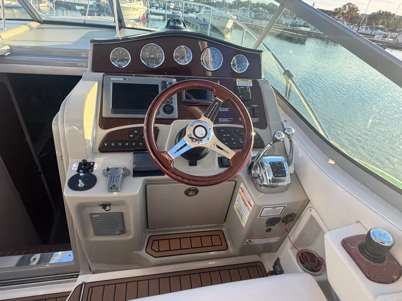 Slide: The Image of 2011 Sea Ray 330 Sundancer helm with wooden steering wheel. - 13