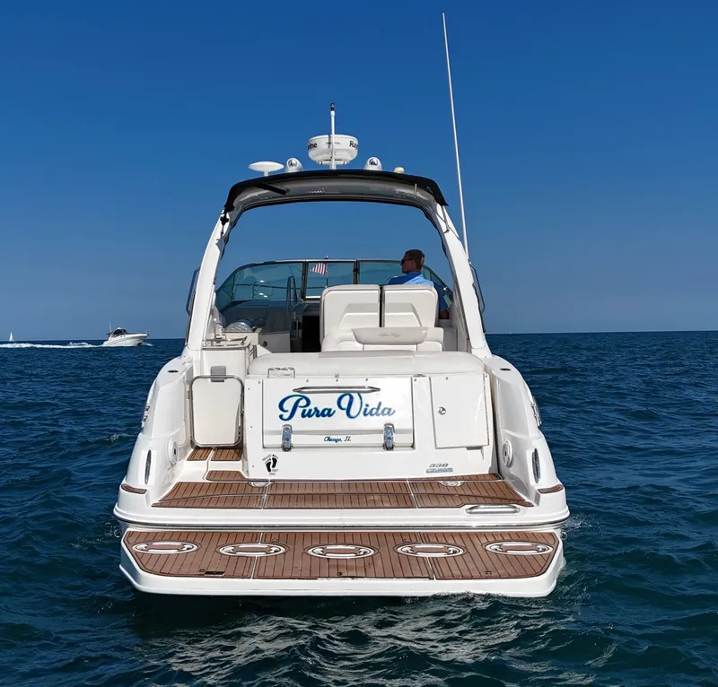 Slide: The Image of A 2011 Sea Ray Sundancer 330 on the water. It features a spacious aft deck and white exterior. - 2