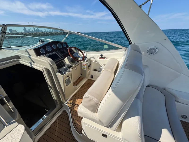 Slide: The Image of The image shows the cockpit of a 2011 Sea Ray Sundancer 330 with white seating and wood accents. - 8
