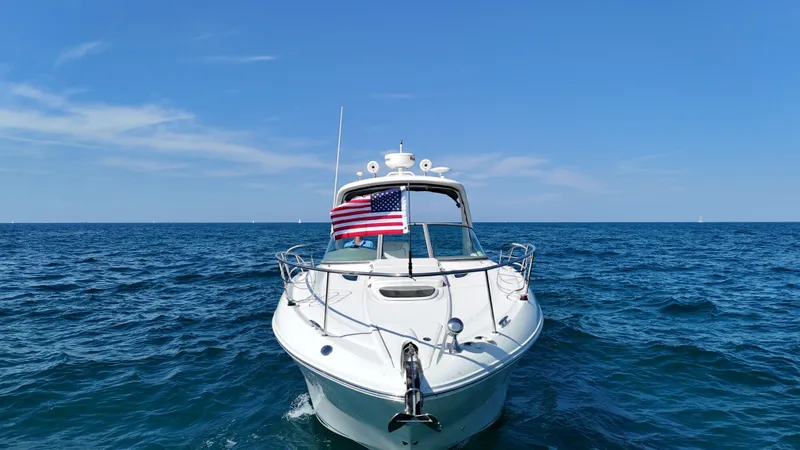 Slide: The Image of A 2011 Sea Ray Sundancer 330 on open water, featuring an American flag. - 20