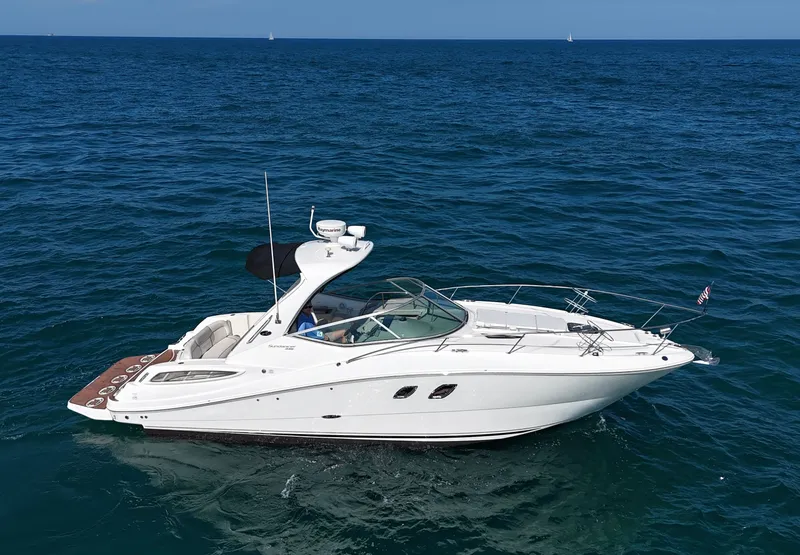 The Image of The 2011 Sea Ray Sundancer 330 cruises on calm, blue waters. It features a sleek, white design. - 0