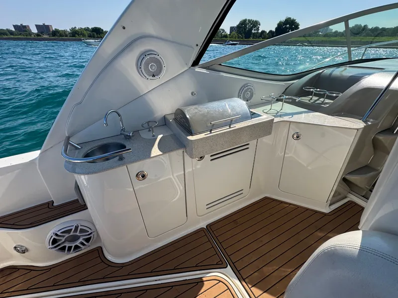 Slide: The Image of The 2011 Sea Ray Sundancer 330 features an elegant outdoor kitchen with a sink and grill. - 7