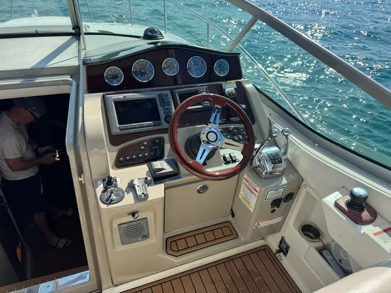 Slide: The Image of The cockpit of a 2011 Sea Ray Sundancer 330 with a wooden steering wheel and modern instruments. - 5