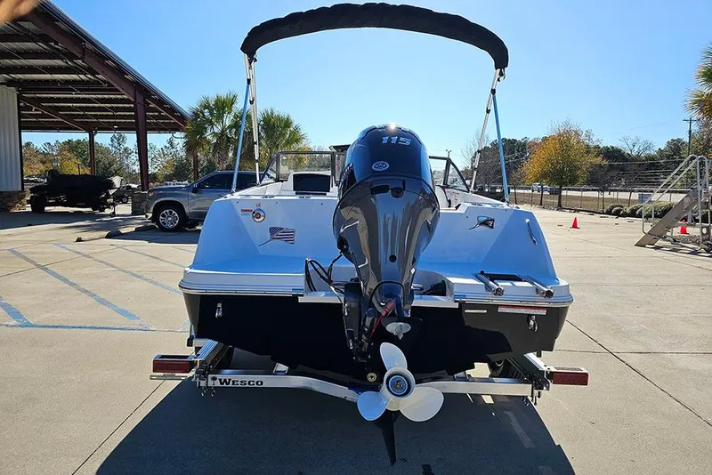 Slide: The Image of 2026 Stingray 172 DC boat with outboard motor on trailer in sunny parking lot. - 8