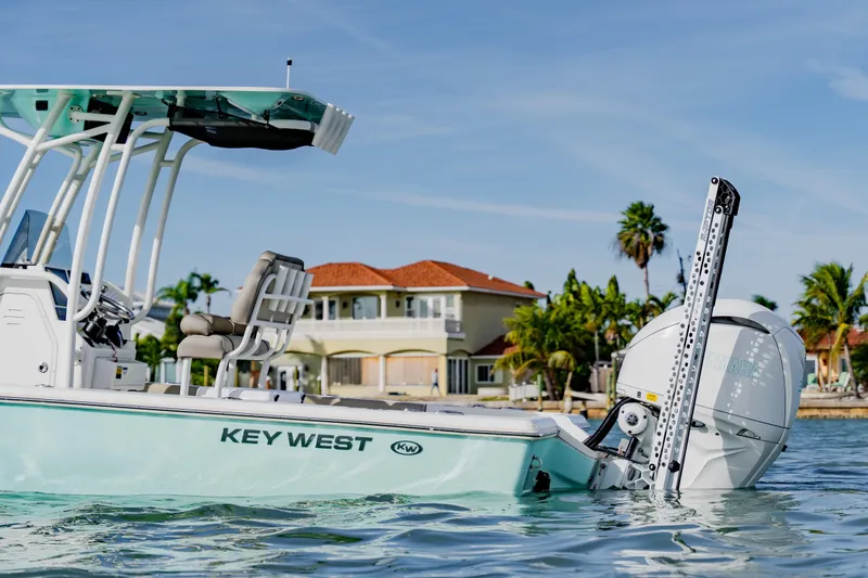 Slide: The Image of 2024 Key West 250 Bay Reef boat on water, with tropical house and palm trees in background. - 12