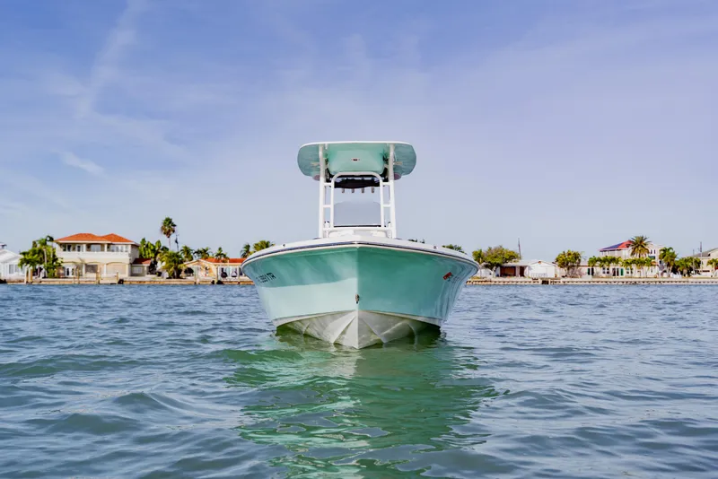 Slide: The Image of 2024 Key West 250 Bay Reef boat on calm water near coastal homes. - 14