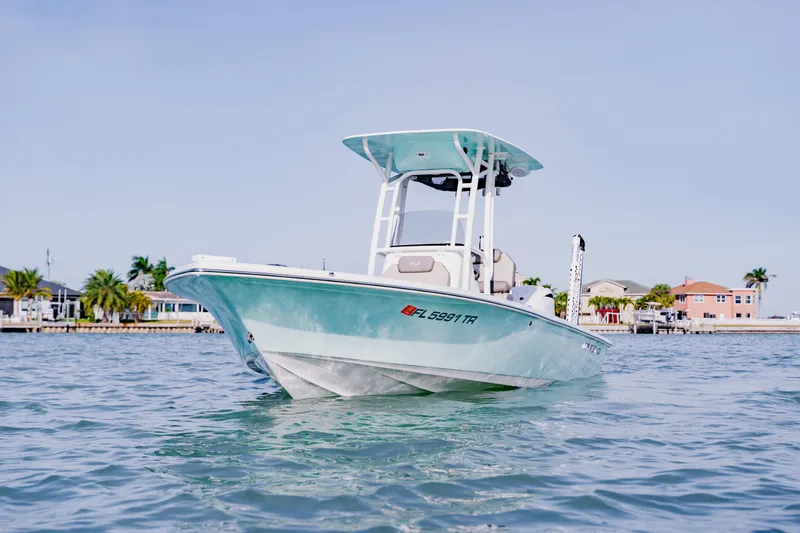 Slide: The Image of 2024 Key West 250 Bay Reef boat on calm water, near coastal homes. - 15