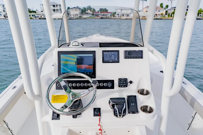 Slide: The Image of 2024 Key West 250 Bay Reef boat dashboard with modern navigation equipment and controls. - 24