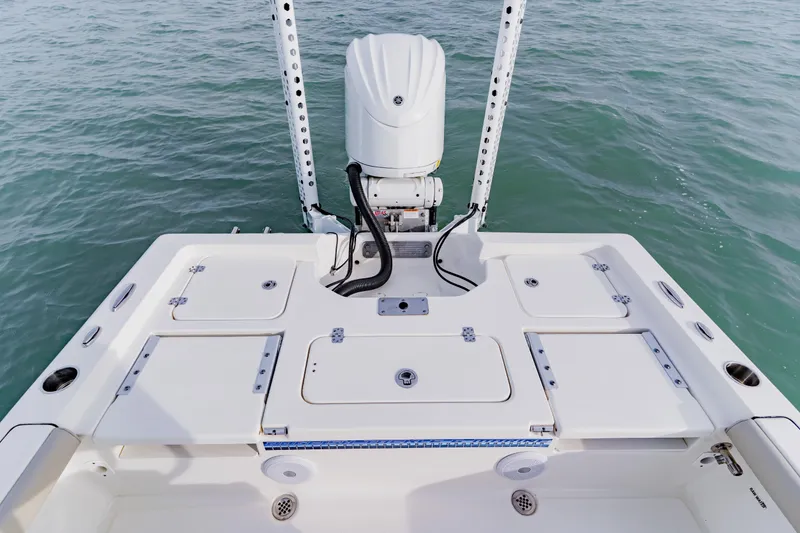 Slide: The Image of 2024 Key West 250 Bay Reef boat stern view with motor and storage compartments. - 26