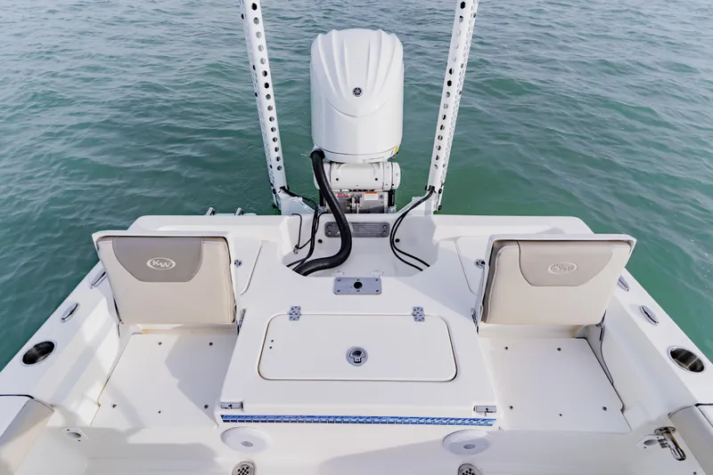 Slide: The Image of 2024 Key West 250 Bay Reef boat's rear deck with seating and motor on water. - 27