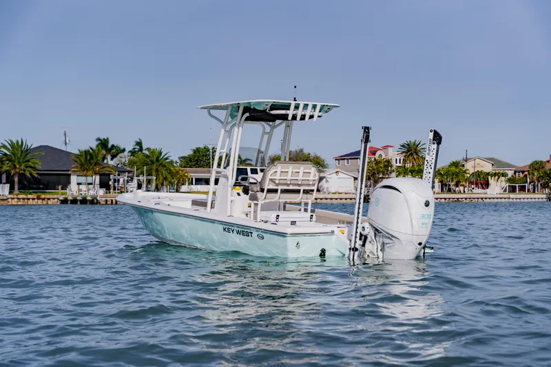 Slide: The Image of 2024 Key West 250 Bay Reef boat on calm water near a coastal neighborhood. - 5