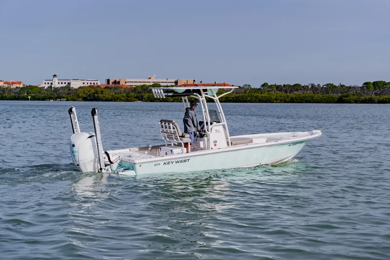 Slide: The Image of 2024 Key West 250 Bay Reef boat cruising on calm waters near a scenic shoreline. - 8