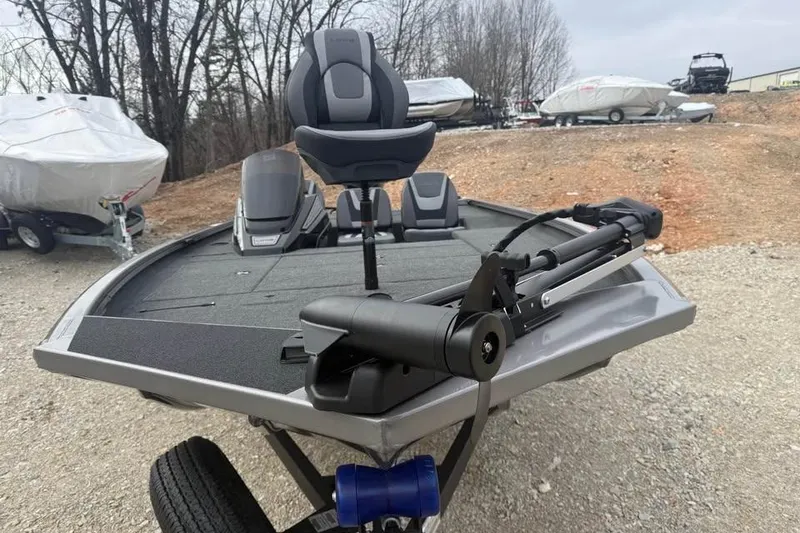 Slide: The Image of 2026 Lowe Stinger 175C fishing boat with trolling motor and seating, parked outdoors. - 2