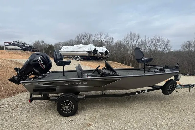 Slide: The Image of 2026 Lowe Stinger 175C fishing boat on trailer, parked outdoors. - 4