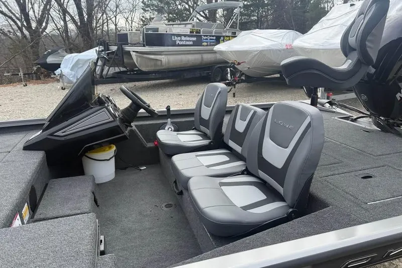 Slide: The Image of 2026 Lowe Stinger 175C boat interior with gray seating and steering console. - 8