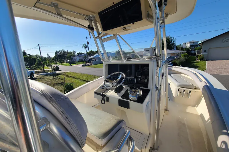 Slide: The Image of 2002 Scout 280 Sportfish boat interior with steering console and seating, parked in a residential area. - 10
