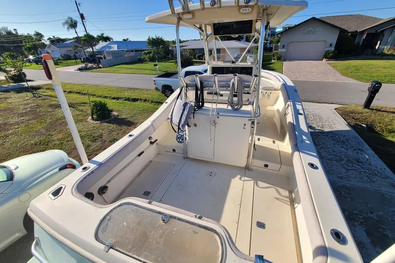 Slide: The Image of 2002 Scout 280 Sportfish boat parked in a residential driveway, showcasing spacious deck. - 14