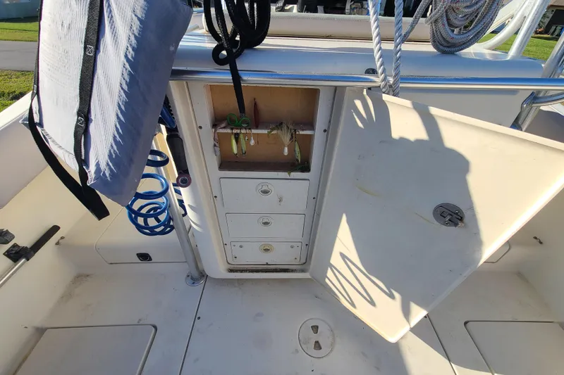 Slide: The Image of 2002 Scout 280 Sportfish boat storage area with open compartments and fishing gear. - 16