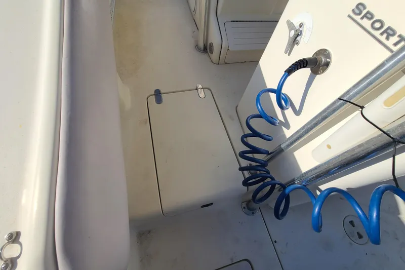 Slide: The Image of 2002 Scout 280 Sportfish deck with coiled blue hose and storage compartment. - 17