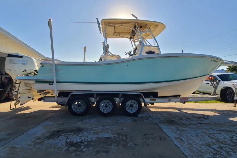 Slide: The Image of 2002 Scout 280 Sportfish boat on trailer, parked in driveway, sunny day. - 2