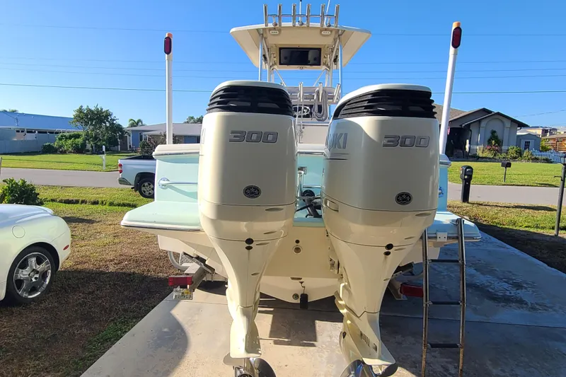 Slide: The Image of 2002 Scout 280 Sportfish with dual Suzuki 300 engines parked in driveway. - 3