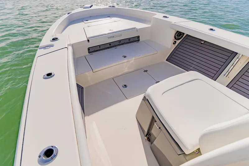 Slide: The Image of 2023 Pathfinder 2700 Open boat interior with seating and storage on calm water. - 15