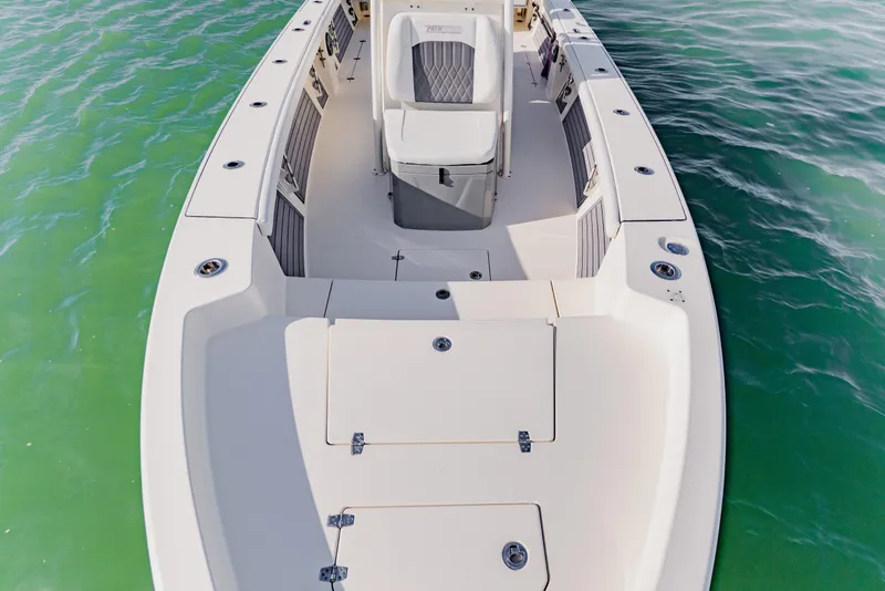 Slide: The Image of 2023 Pathfinder 2700 Open boat on calm green water, showcasing spacious deck design. - 16