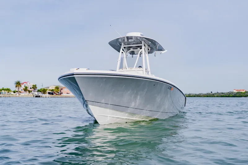 Slide: The Image of 2023 Pathfinder 2700 Open boat on calm water, with coastal homes in the background. - 2